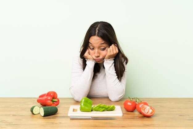 Young brunette woman with lots of vegetables