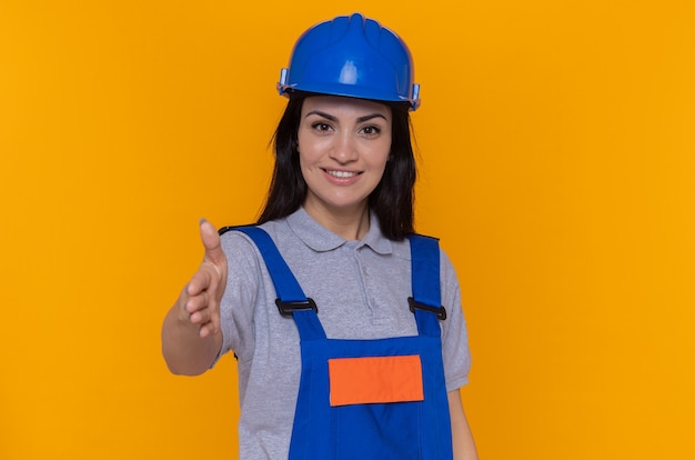 young builder woman in construction uniform and safety helmet