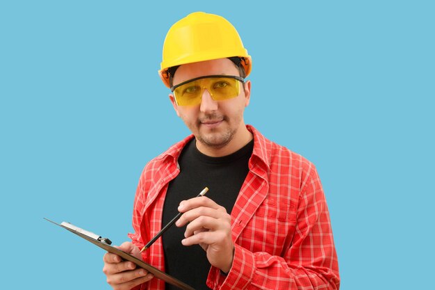 Young builder or worker looking at camera on blue background Construction teamwork