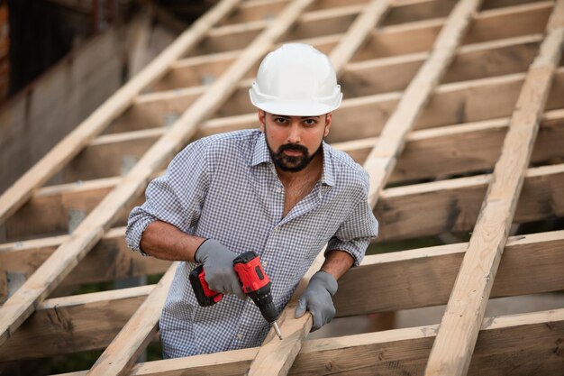 The young builder works on an unfinished roof