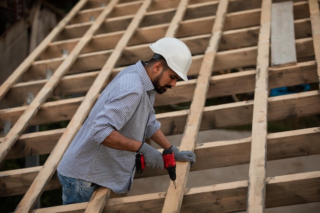 The young builder works on an unfinished roof