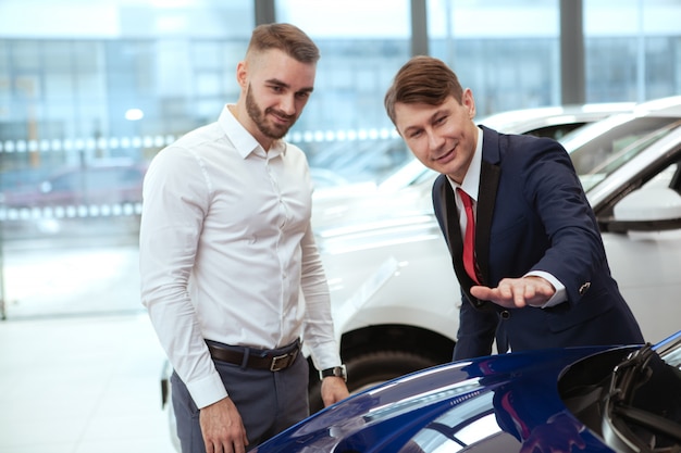 Foto giovane uomo d'affari che compra nuova automobile