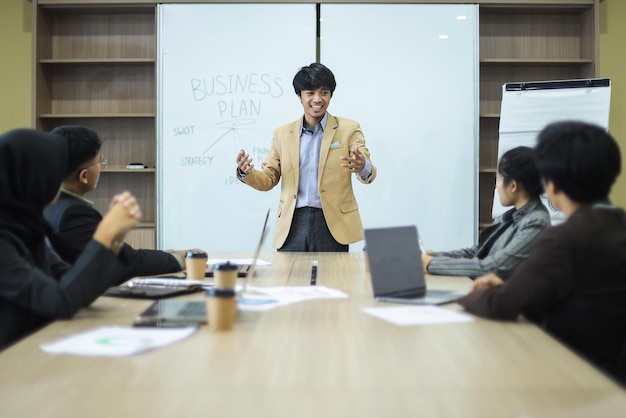 Young businesman present business plan to worker during meeting at the office.