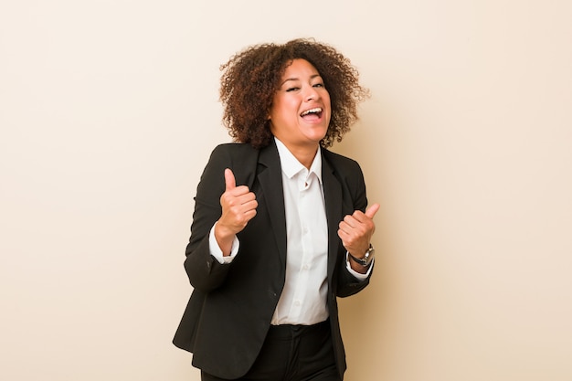 Photo young business african american woman raising both thumbs up, smiling and confident.