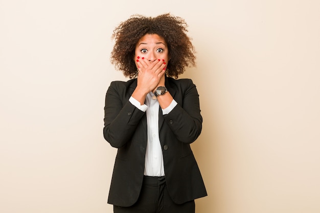 Young business african american woman shocked covering mouth with hands.