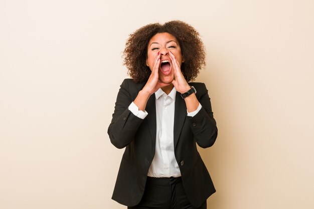 Young business african american woman shouting excited to front.