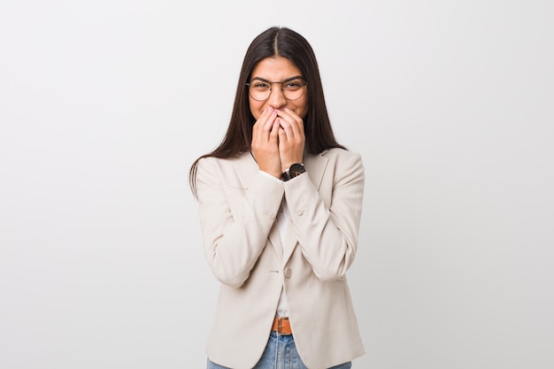 Young business arab woman  against a white background laughing about something, covering mouth with hands.