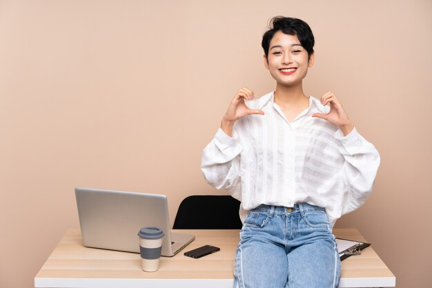 Young business Asian girl in her workplace proud and self-satisfied