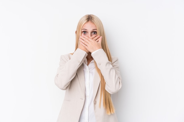 Young business blonde woman on white wall shocked covering mouth with hands.
