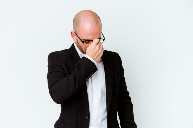 Young business caucasian bald man on blue having a head ache, touching front of the face.