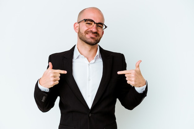 Young business caucasian bald man isolated on blue background points down with fingers, positive feeling.