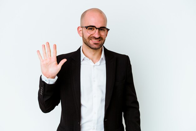 Young business caucasian bald man isolated on blue wall smiling cheerful showing number five with fingers.