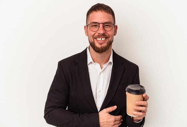 Young business caucasian man holding take away coffee isolated on white background laughing and having fun.