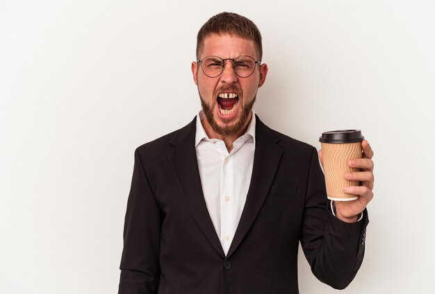 Young business caucasian man holding take away coffee isolated on white background screaming very angry and aggressive.