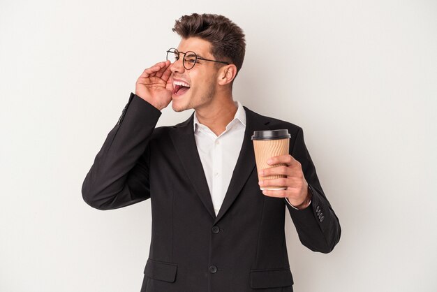 Young business caucasian man holding take away coffee isolated on white background shouting and holding palm near opened mouth.