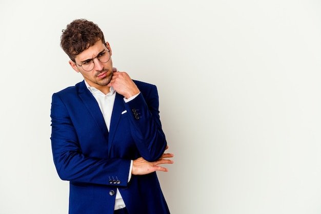 Young business caucasian man isolated on white background looking sideways with doubtful and skeptical expression.