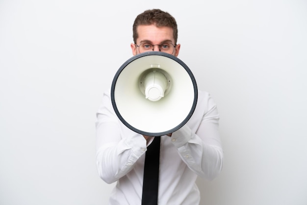 Young business caucasian man isolated on white background shouting through a megaphone