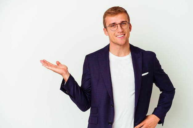 Young business caucasian man isolated on white background showing a copy space on a palm and holding another hand on waist.