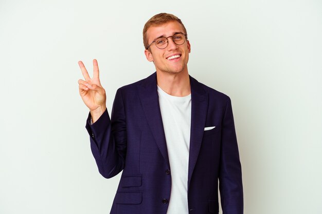 Young business caucasian man isolated on white joyful and carefree showing a peace symbol with fingers.