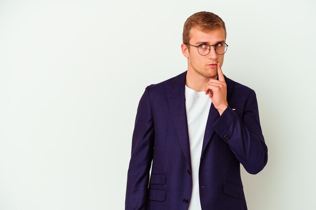 Young business caucasian man isolated on white looking sideways with doubtful and skeptical expression.