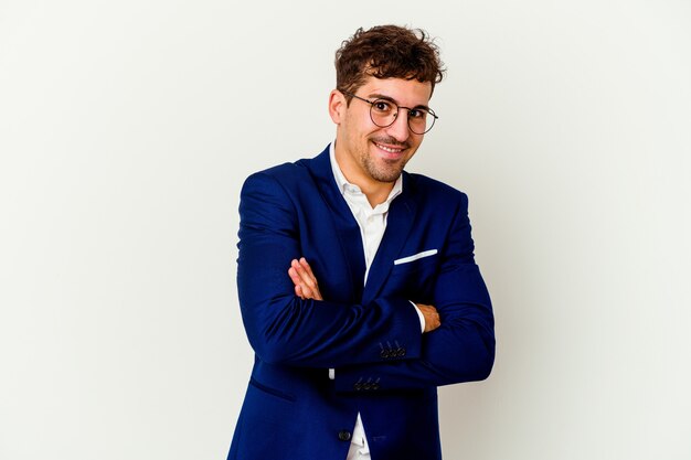 Young business caucasian man isolated on white wall laughing and having fun