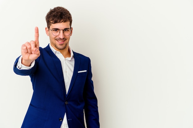 Young business caucasian man isolated on white wall shocked and amazed holding a copy space between hands.