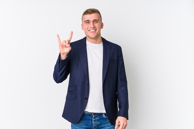 Young business caucasian man showing a horns gesture as a revolution concept.