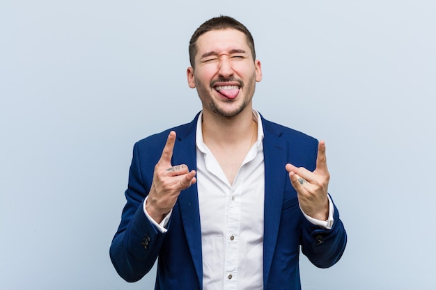 Young business caucasian man showing rock gesture with fingers