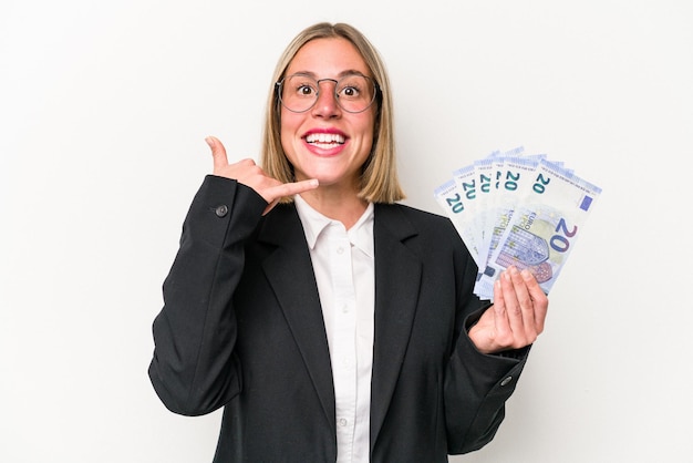 Young business caucasian woman holding banknotes isolated on white background showing a mobile phone call gesture with fingers