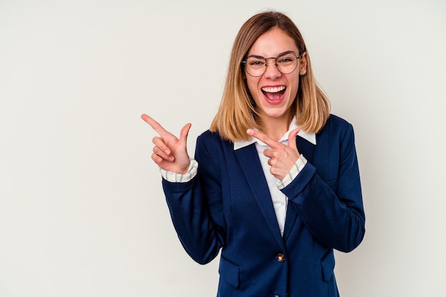 Young business caucasian woman isolated on white pointing with forefingers to a copy space, expressing excitement and desire.