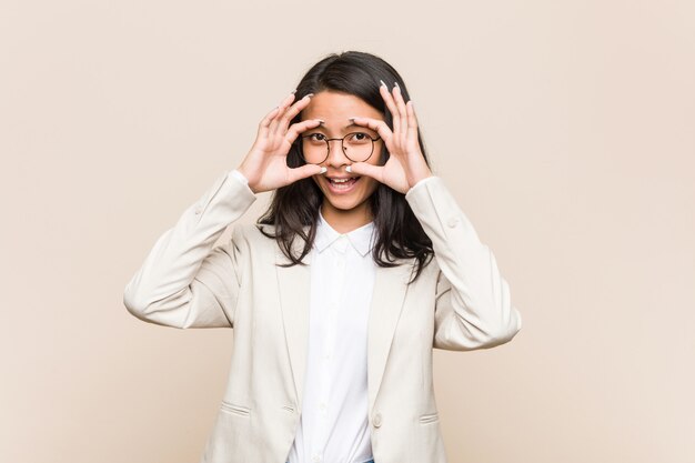 Young business chinese woman keeping eyes opened to find a success opportunity.