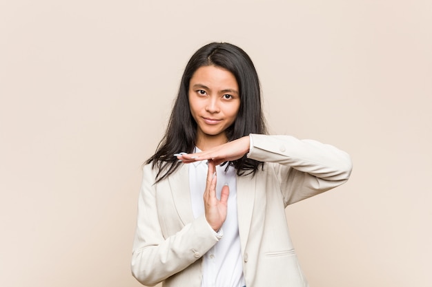 Young business chinese woman showing a timeout gesture.