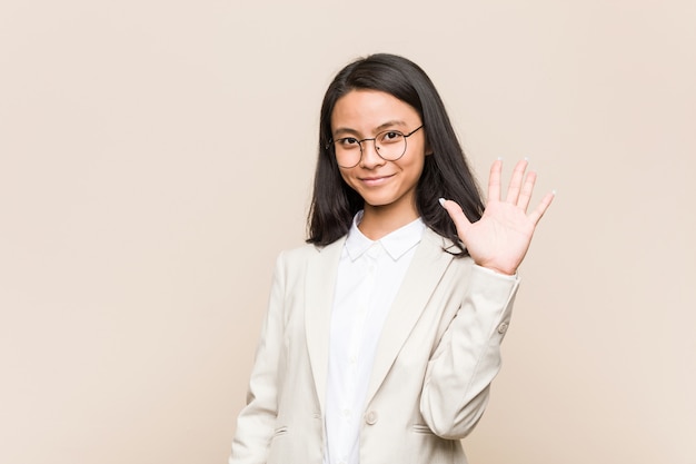 Young business chinese woman smiling cheerful showing number five with fingers.