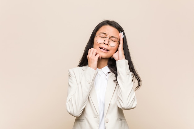 Young business chinese woman whining and crying disconsolately.