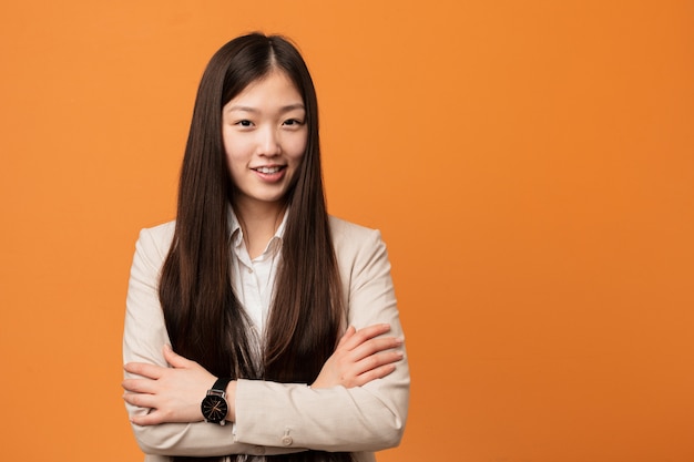 Young business chinese woman who feels confident, crossing arms with determination.