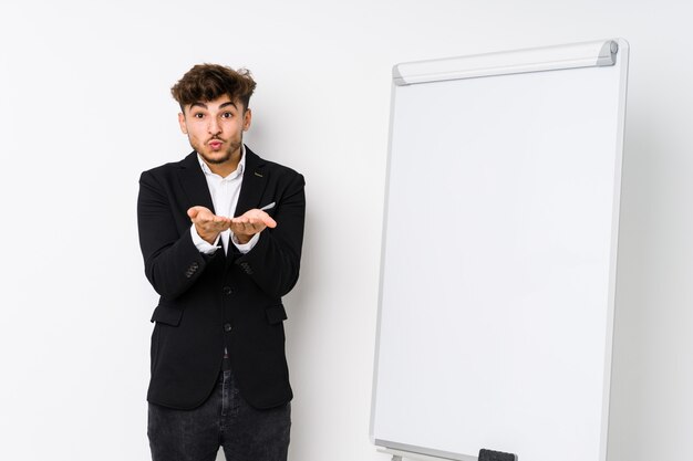 Young business coachingian man folding lips and holding palms to send air kiss