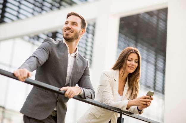 Young business couple looking at the phone outdoor