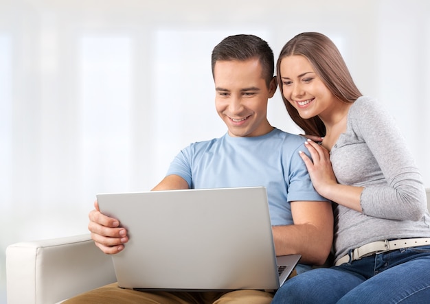 Young business couple using laptop at home, online shopping with credit card