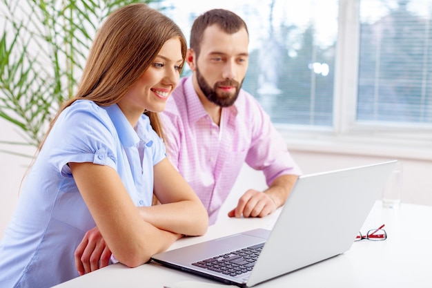 Young business couple work with laptop in office