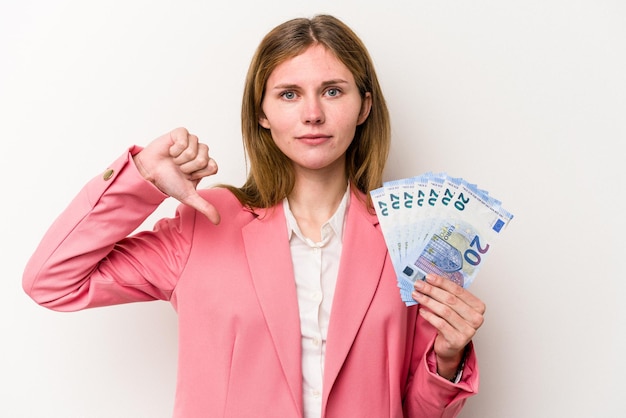 Young business English woman holding banknotes isolated on white background showing a dislike gesture, thumbs down. Disagreement concept.