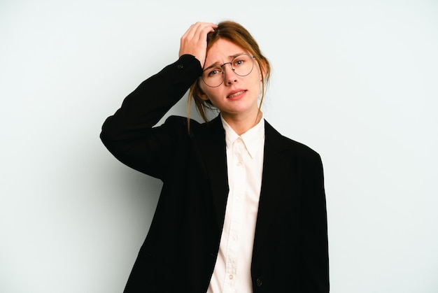 Young business English woman isolated on blue background being shocked, she has remembered important meeting.