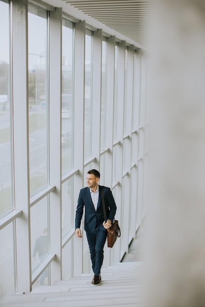 Young business executive with briefcase going up the stairs