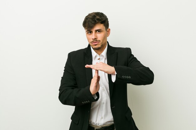 Young business hispanic man showing a timeout gesture.