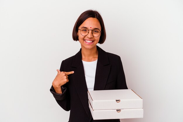 Young business indian woman holding pizzas isolated person pointing by hand to a shirt copy space, proud and confident