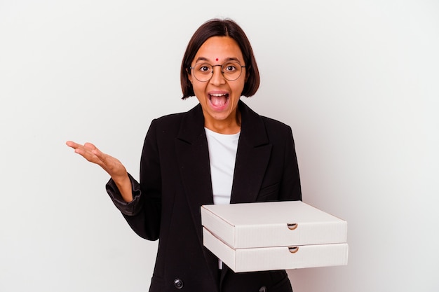 La giovane donna indiana di affari che tiene le pizze ha isolato la ricezione di una piacevole sorpresa, eccitata e alzando le mani.