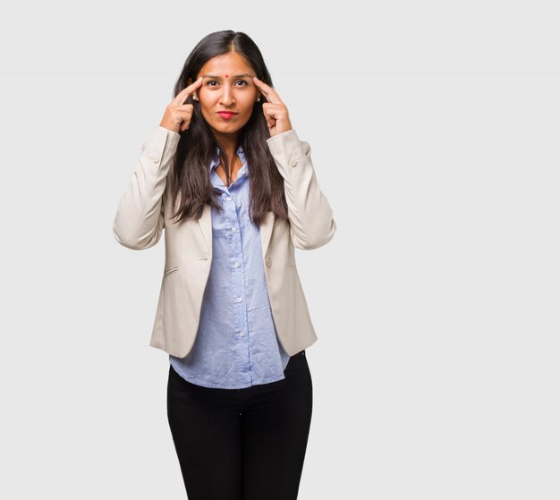 Young business indian woman man making a concentration gesture, looking straight ahead focused on a goal