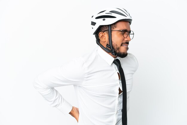 Young business latin man holding a bike helmet isolated on white background suffering from backache for having made an effort