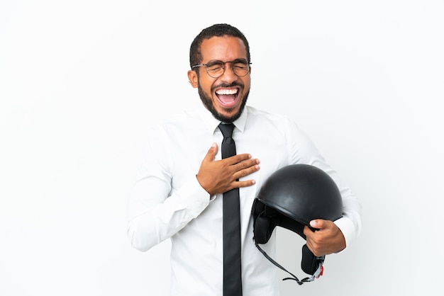 Молодой деловой латинский человек с мотоциклетным шлемом на белом фоне много улыбается