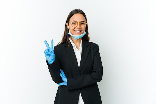 指で2番目を示すcovidから保護するためにマスクを身に着けている若いビジネスラテン女性。