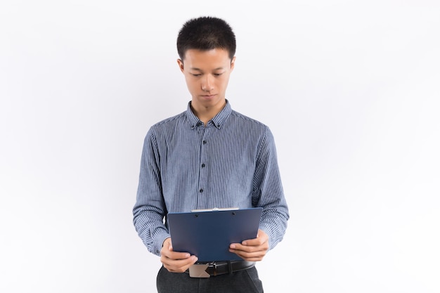 Young business male holding a folder standing in front of white background